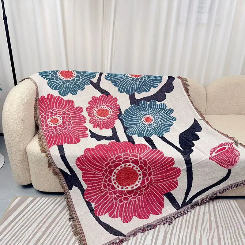 Blue Geometric Knitted Throw Decorbites draped over beige sofa with pink and blue floral pattern on Tampa Home & Garden Store