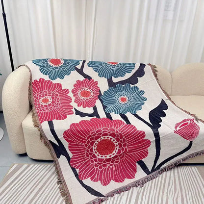Blue Geometric Knitted Throw Decorbites draped over beige sofa with pink and blue floral pattern on Tampa Home & Garden Store