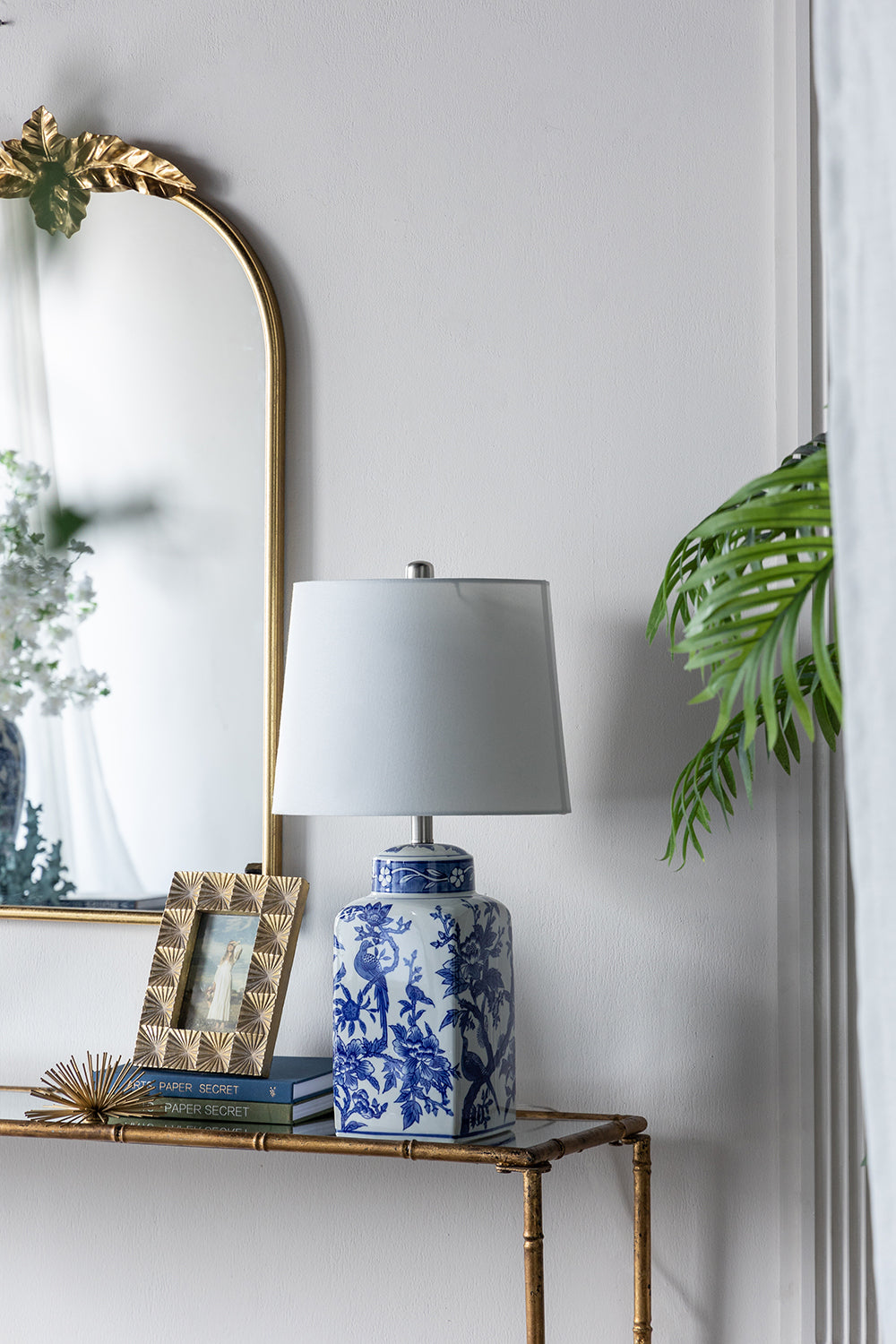 Blue and white ceramic vase lamp with floral pattern and white shade on brass console table on Tampa Home & Garden Store