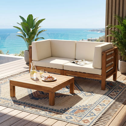 Oana 3-Piece Loveseat Set with Coffee Table in acacia with white cushions on oceanfront deck on Tampa Home & Garden Store