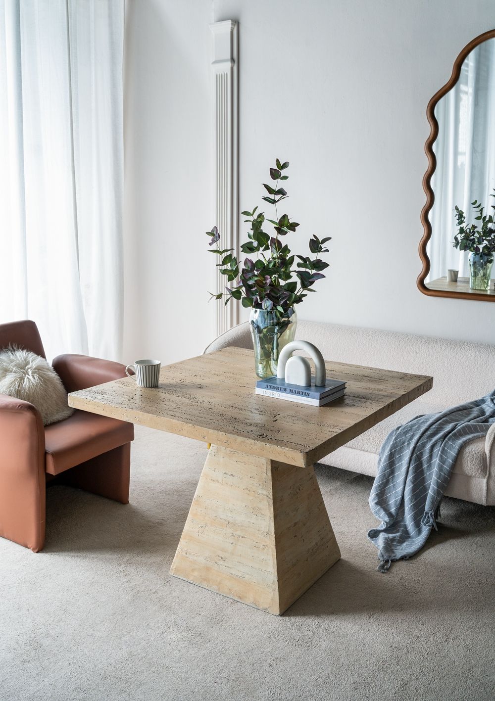 Square beige dining table with pedestal base in a cozy living area by HouseOfZazla on Tampa Home & Garden Store