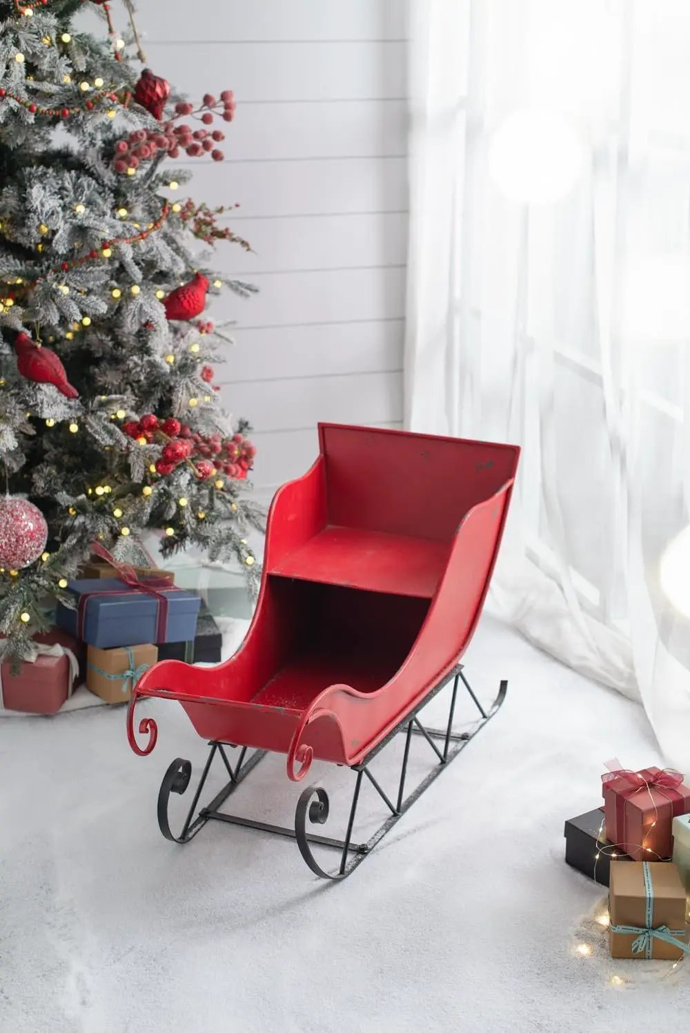 Large red iron Santa sleigh decoration with a distressed finish and black metal runners on Tampa Home & Garden Store