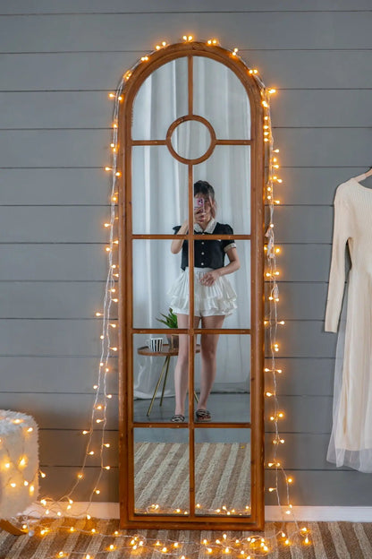 Arched mirror in brown solid fir wood with windowpane design and string lights on Tampa Home & Garden Store