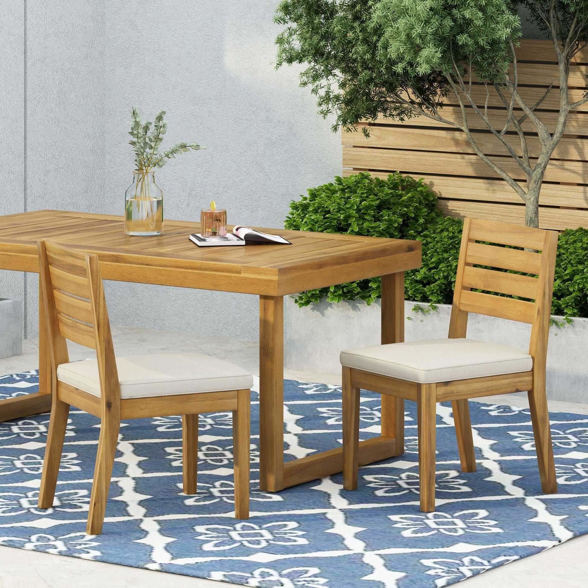 Wooden outdoor armless dining chairs with beige cushions around a wooden table on Tampa Home & Garden Store