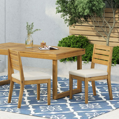 Wooden outdoor armless dining chairs with beige cushions around a wooden table on Tampa Home & Garden Store
