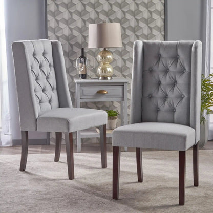 Two gray tufted dining chairs with high backs and dark wood legs beside a white side table on Tampa Home & Garden Store