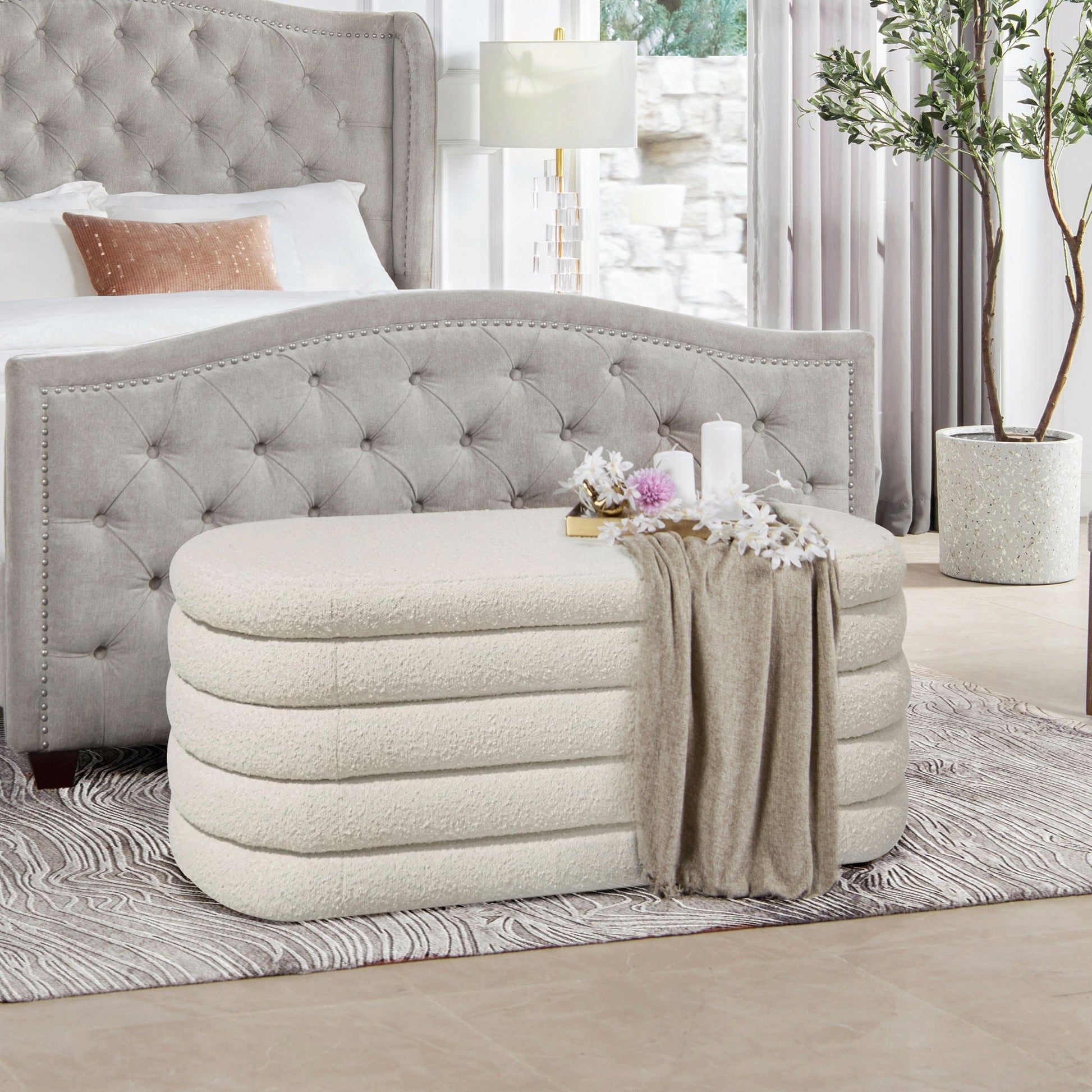 Fuji Upholstered Oval Storage Bench in gray tufted fabric with nailhead trim at foot of bed on Tampa Home & Garden Store
