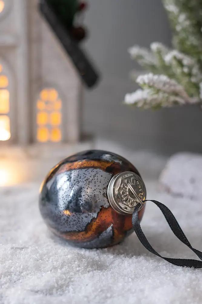 Christmas ball ornament with marbled brown blue silver surface and black ribbon on snow on Tampa Home & Garden Store