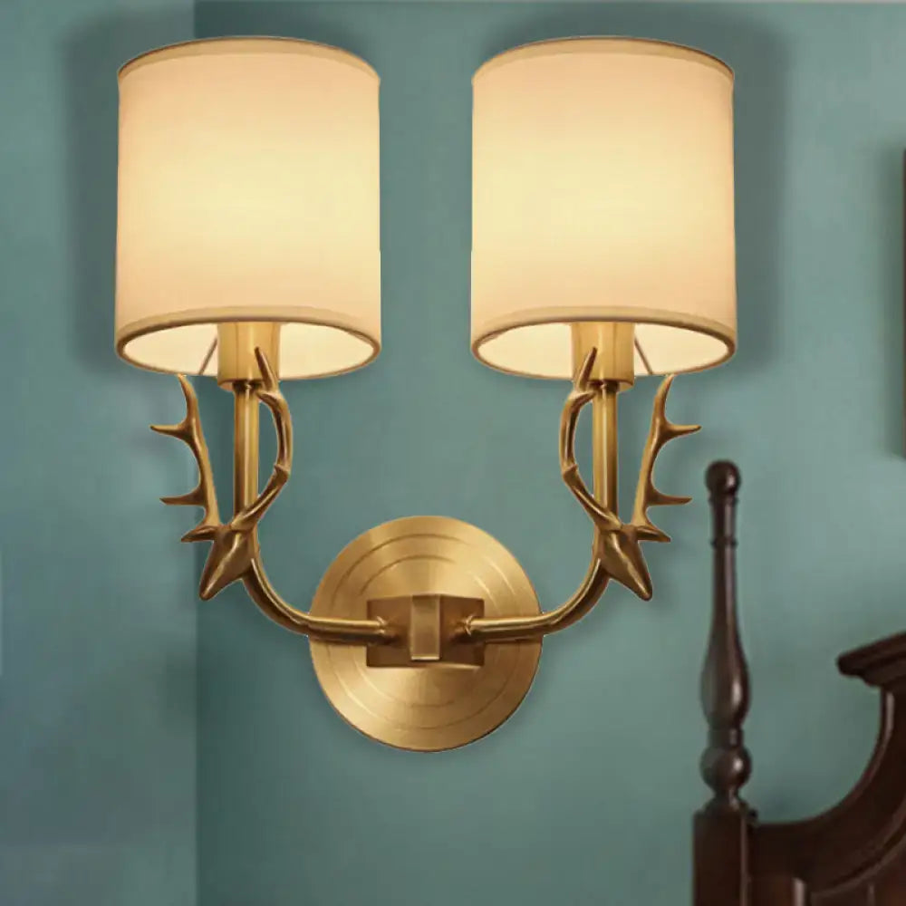 Antique brass fabric sconce by Decorbites with twin antler arms and cream shades on Tampa Home & Garden Store