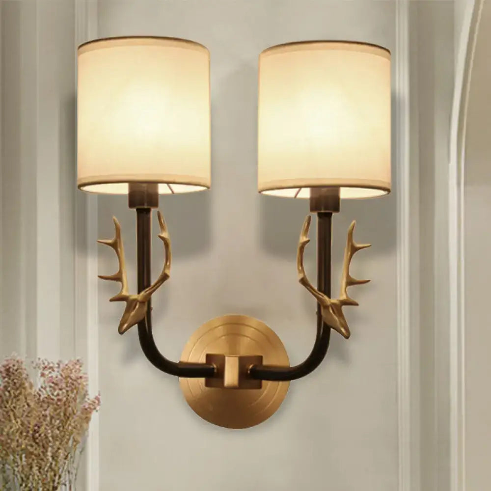 Antique Brass Fabric Sconce, twin lights with antler-brass arms and cream drum shades on Tampa Home & Garden Store