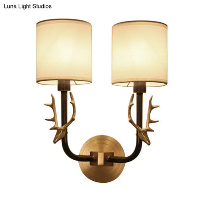 Antique Brass Fabric Sconce with dual arms, antler accents, cream shades on Tampa Home & Garden Store