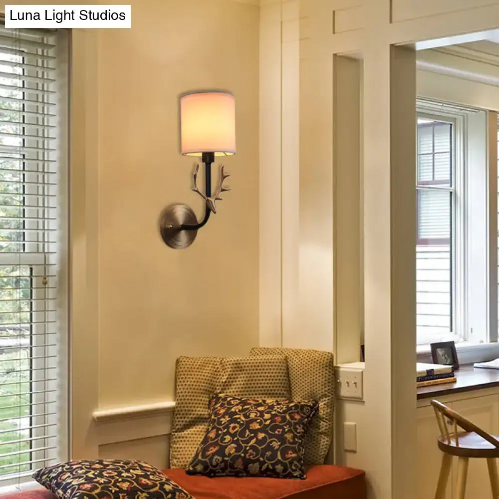 Antique Brass Fabric Sconce with antler-inspired black arm and cream shade on Tampa Home & Garden Store