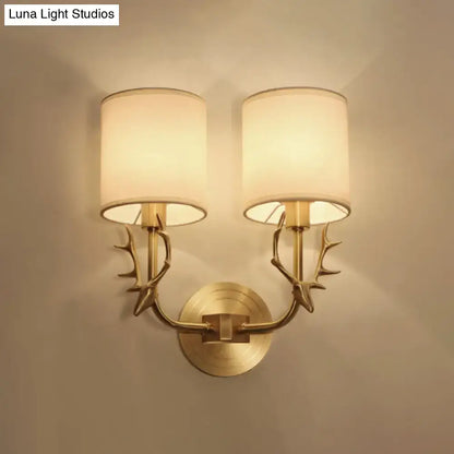 Antique brass fabric sconce with twin antler-style arms and white fabric shades; wall mount on Tampa Home & Garden Store