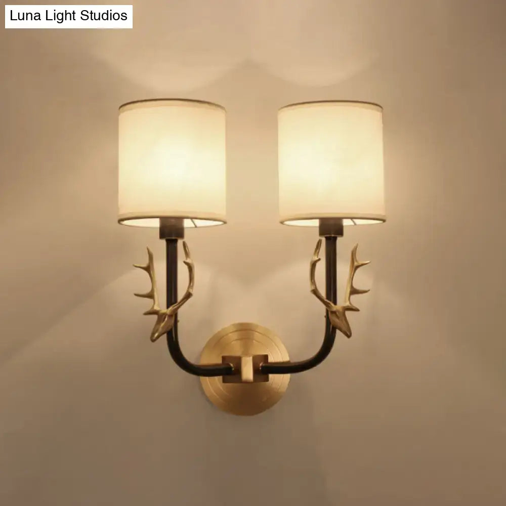 Antique brass fabric sconce with two-light antler-style arms and cream shade by Decorbites on Tampa Home & Garden Store