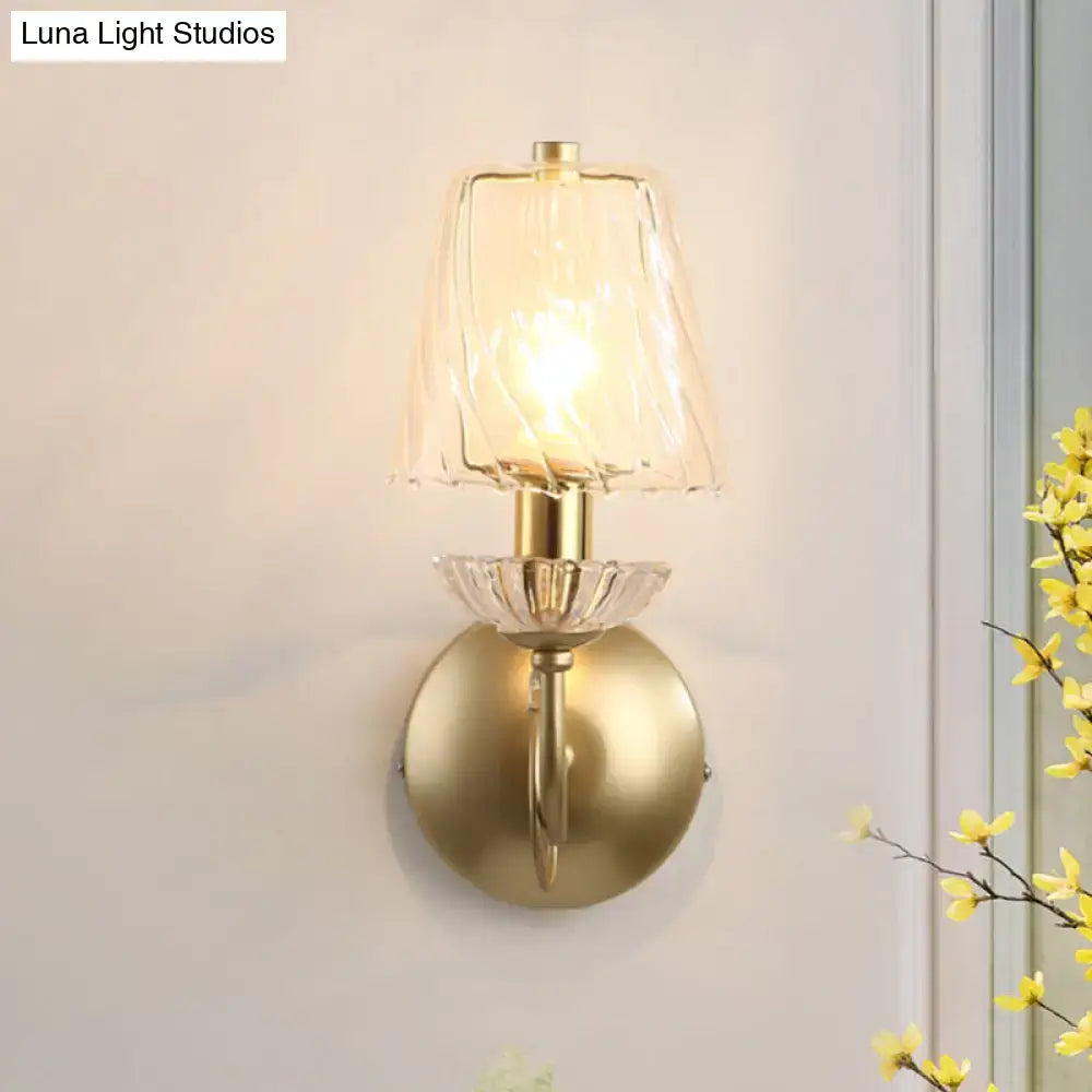 Brass conical wall sconce with clear glass shade and warm glow bulb on Tampa Home & Garden Store