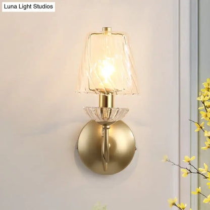 Brass conical wall sconce with clear glass shade and warm glow bulb on Tampa Home & Garden Store