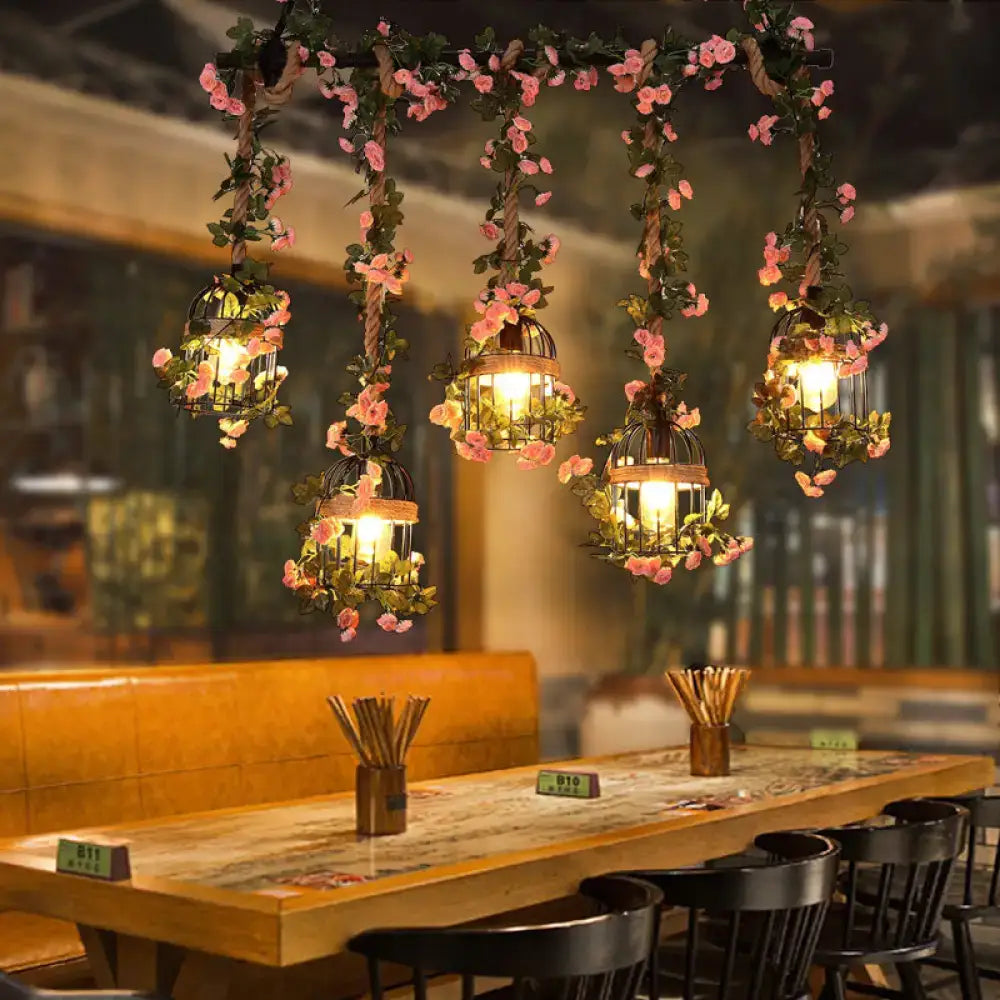 Pink Blossom Ceiling Light with hanging lanterns wrapped in pink flowers over a wooden table on Tampa Home & Garden Store