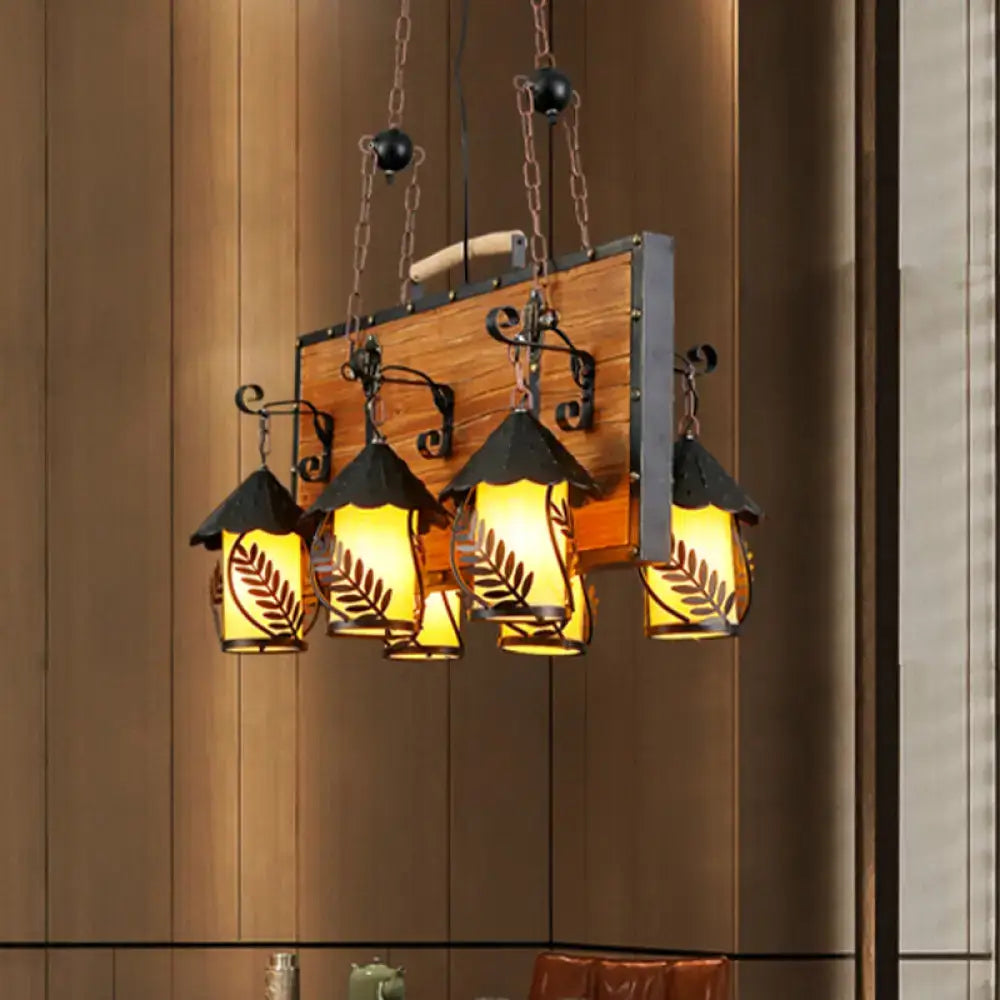 White Glass Chandelier Decorbites with five amber glass lantern shades on a wood backboard on Tampa Home & Garden Store