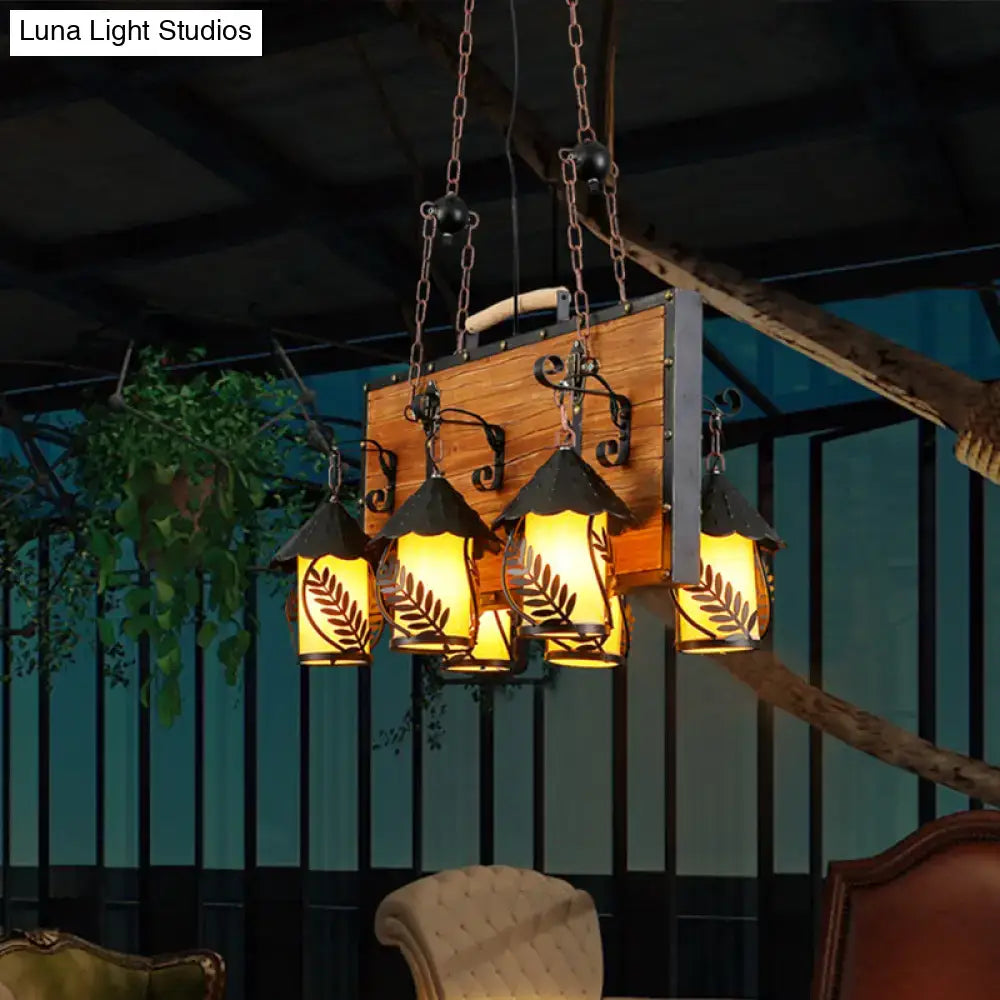 White glass chandelier with five lantern-style lamps on a rustic wood backboard, warm glow on Tampa Home & Garden Store