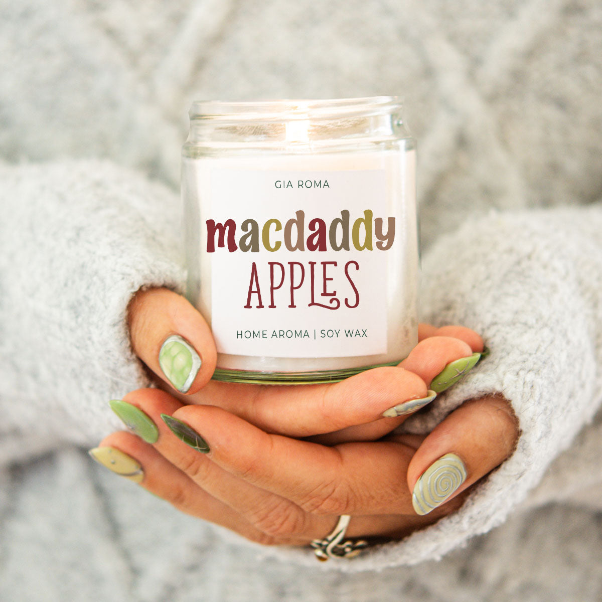 Mac Apple Candle Gia Roma macdaddy apples soy wax in a clear jar held by hands in a grey sweater on Tampa Home & Garden Store
