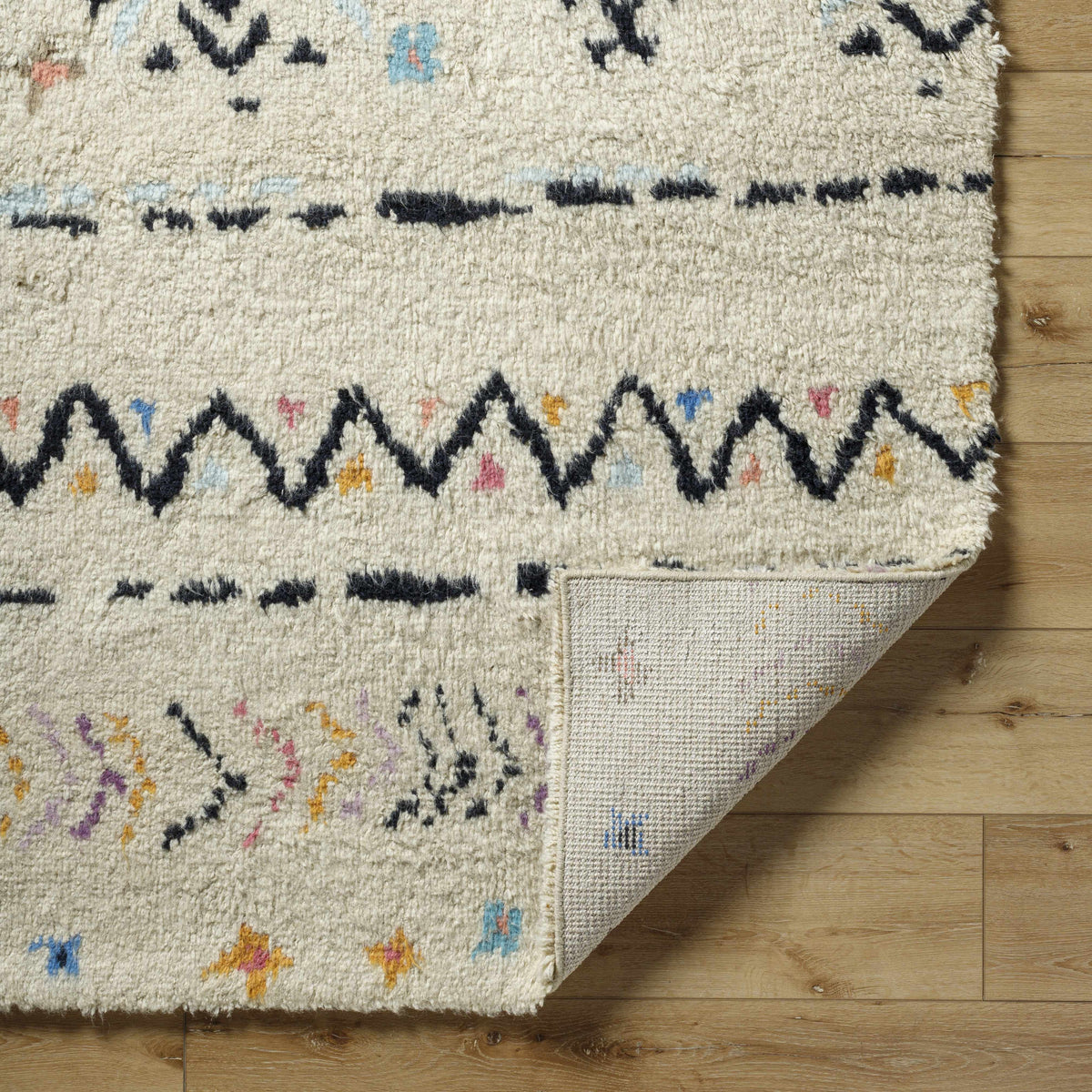 Arcanum hand knotted wool rug in cream with black geometric border and multicolor accents on Tampa Home & Garden Store