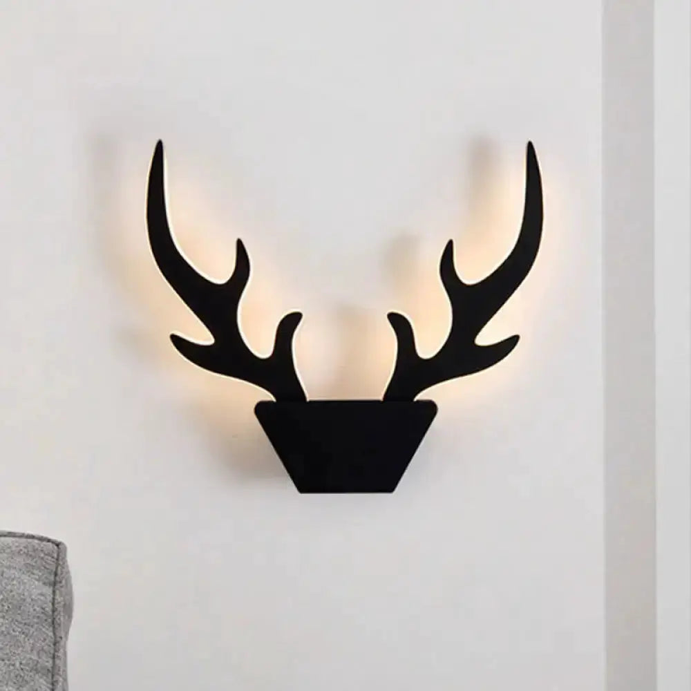 Art deco black antler wall sconce by Decorbites with warm backlit glow on Tampa Home & Garden Store