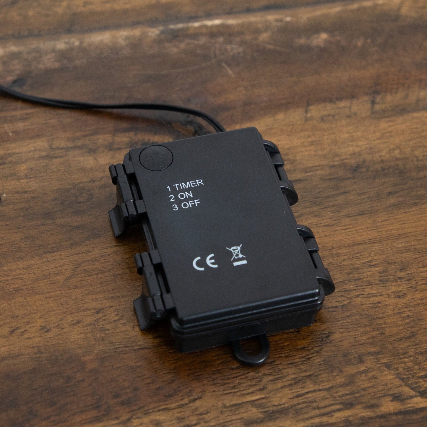Black timer control box displaying 1 TIMER, 2 ON, 3 OFF with power cord on wood surface on Tampa Home & Garden Store