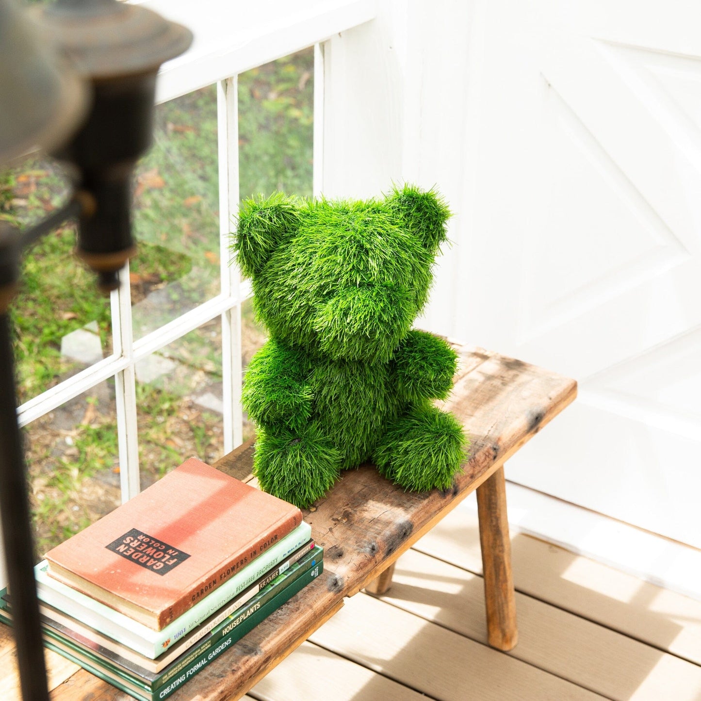 14in UV-resistant artificial grass topiary bear by Nearly Natural on a bench by a white window on Tampa Home & Garden Store