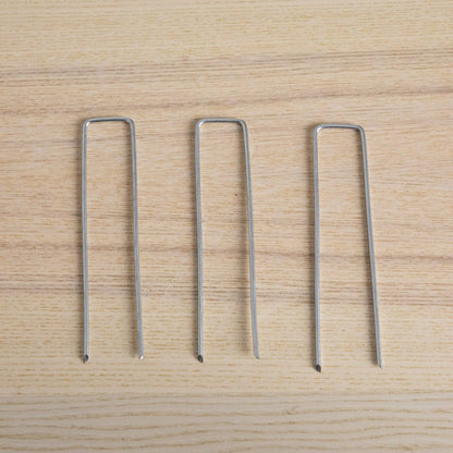 4-pack silver metal U-shaped plant stakes on light wood surface on Tampa Home & Garden Store