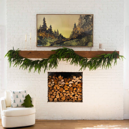 15' Nearly Natural Norfolk Island Pine Garland on a mantle above a white brick fireplace on Tampa Home & Garden Store