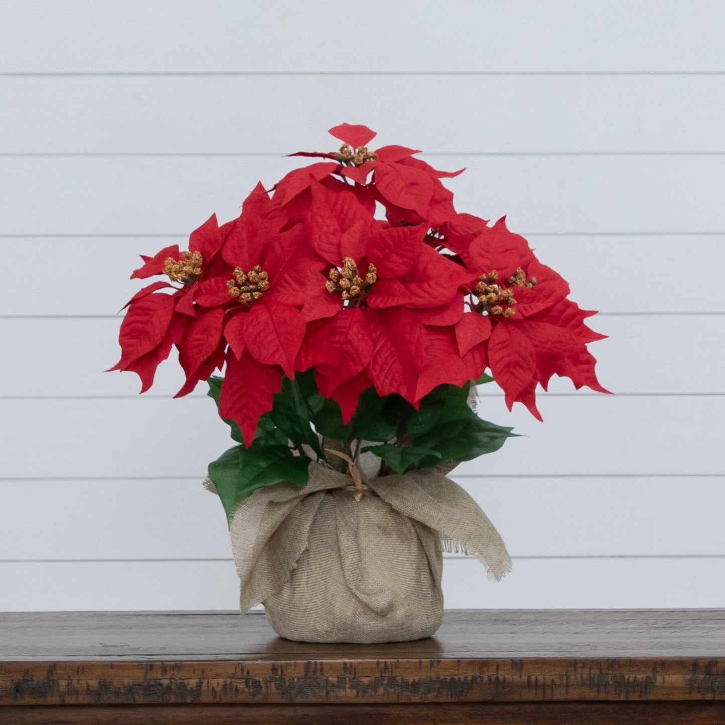 16-inch artificial poinsettia arrangement in burlap planter with red blooms and gold centers on Tampa Home & Garden Store