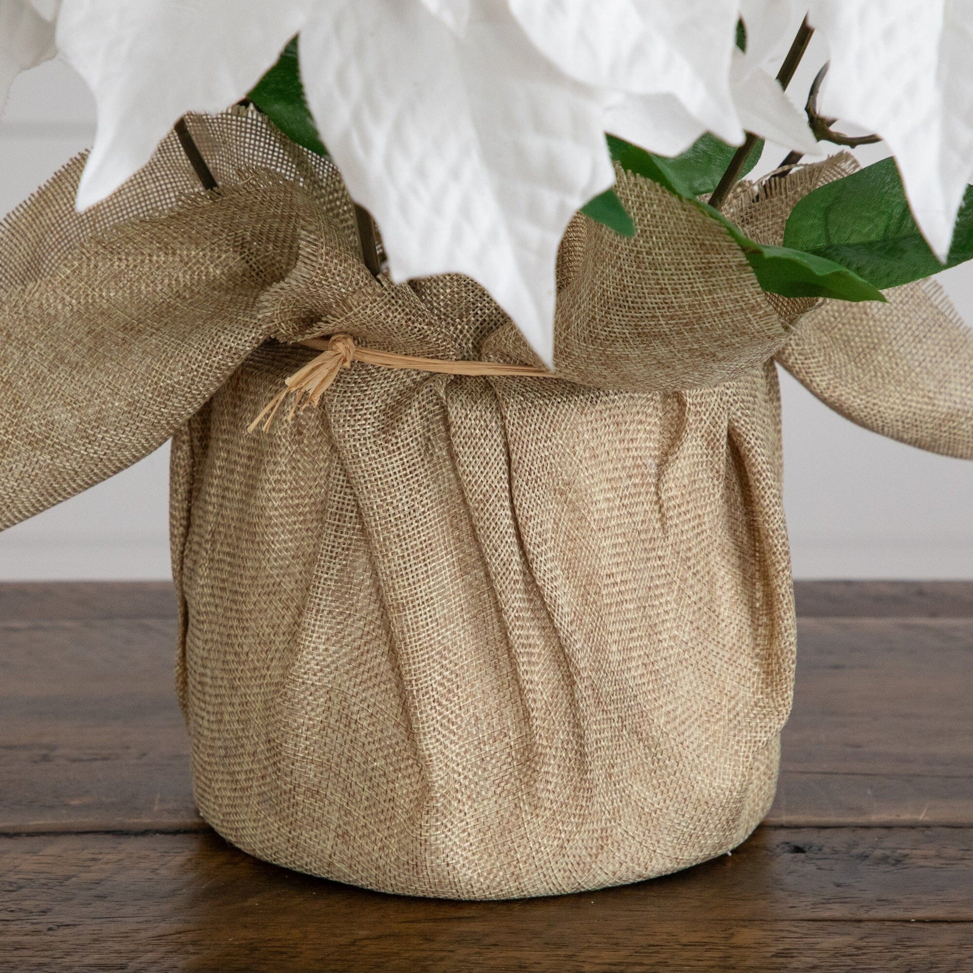 16in artificial poinsettia arrangement in burlap planter with white blooms and green leaves on Tampa Home & Garden Store