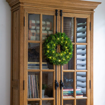 Nearly Natural 18in pre-lit boxwood wreath with 25 warm white LEDs on a wooden cabinet on Tampa Home & Garden Store