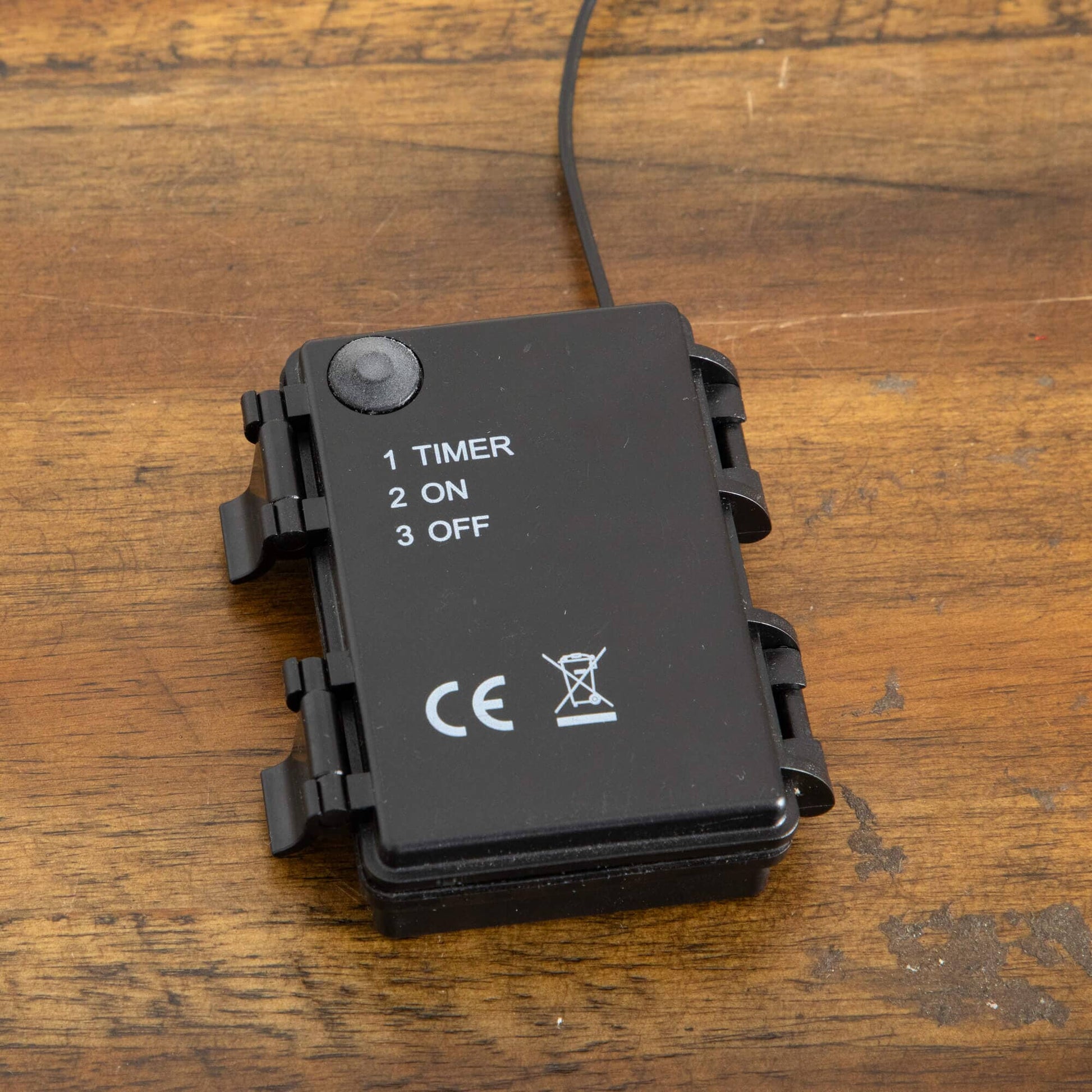 Black timer switch with printed 1 TIMER 2 ON 3 OFF on wooden table cord visible on Tampa Home & Garden Store