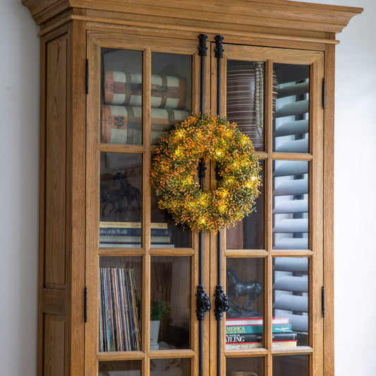 Nearly Natural 18in pre-lit autumn boxwood wreath with 25 warm LEDs in front of a glass cabinet on Tampa Home & Garden Store
