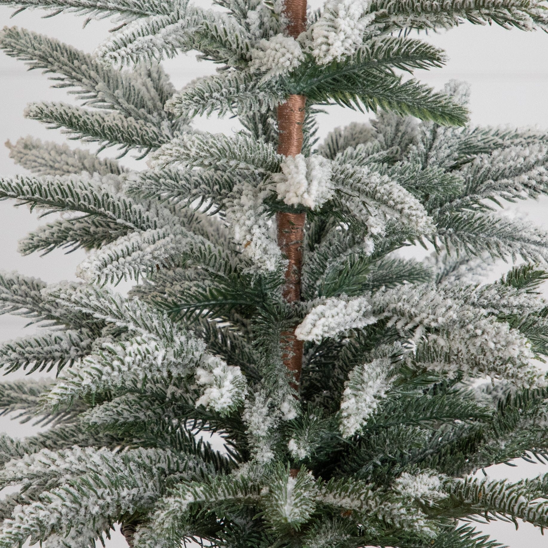 2ft artificial frosted Christmas tree with snow-dusted green needles and brown trunk on Tampa Home & Garden Store