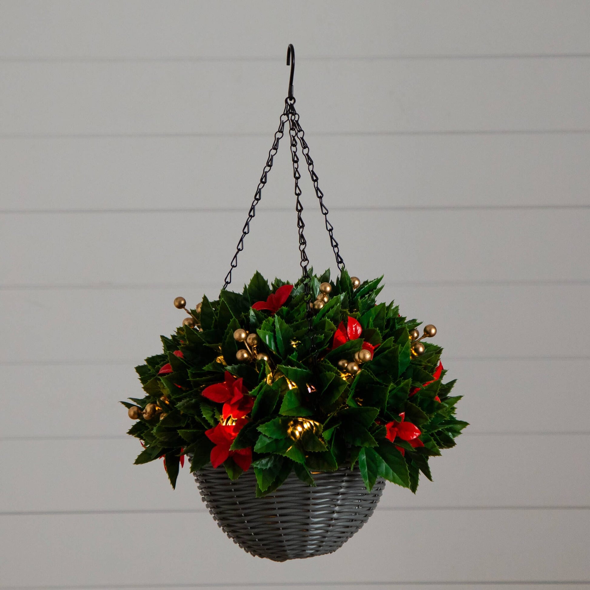 Hanging basket with green Photinia-like leaves, red accents, and gold berry clusters in gray wicker on Tampa Home & Garden Store