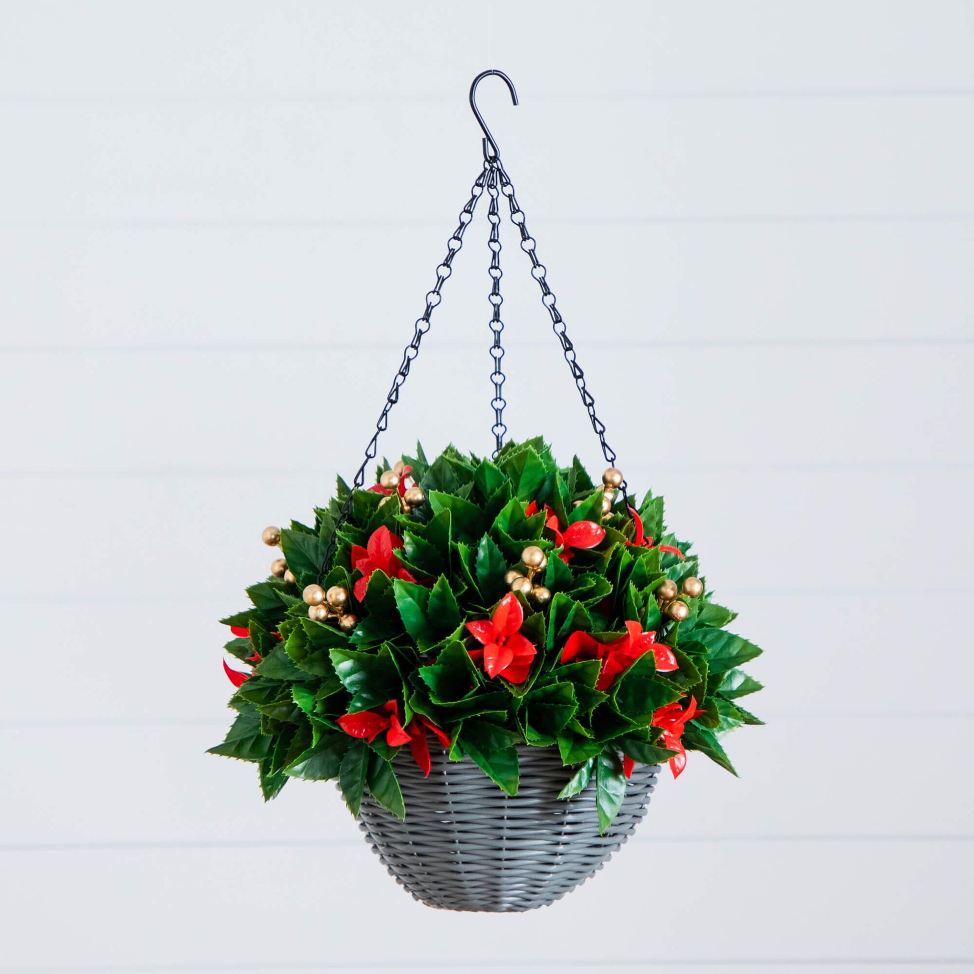 Hanging basket with lush green leaves, red accents, and gold bead trim on a metal chain on Tampa Home & Garden Store