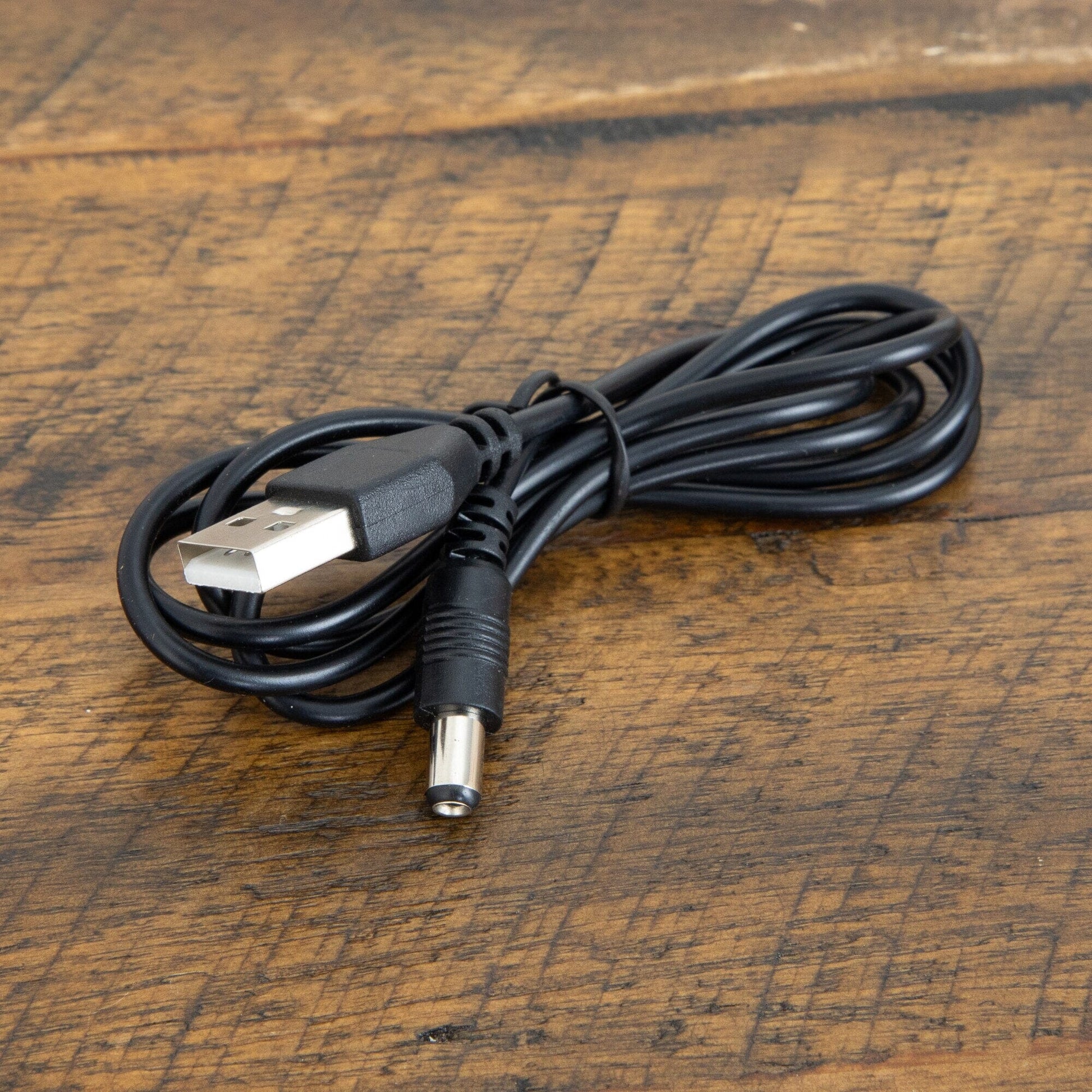 USB power cable, black, coiled with USB-A plug on wood surface on Tampa Home & Garden Store