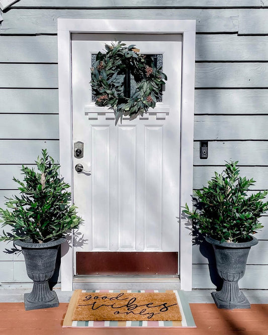 3’ Bay Leaf Artificial Topiary Tree UV Resistant Indoor/Outdoor by a white door with urn planters on Tampa Home & Garden Store