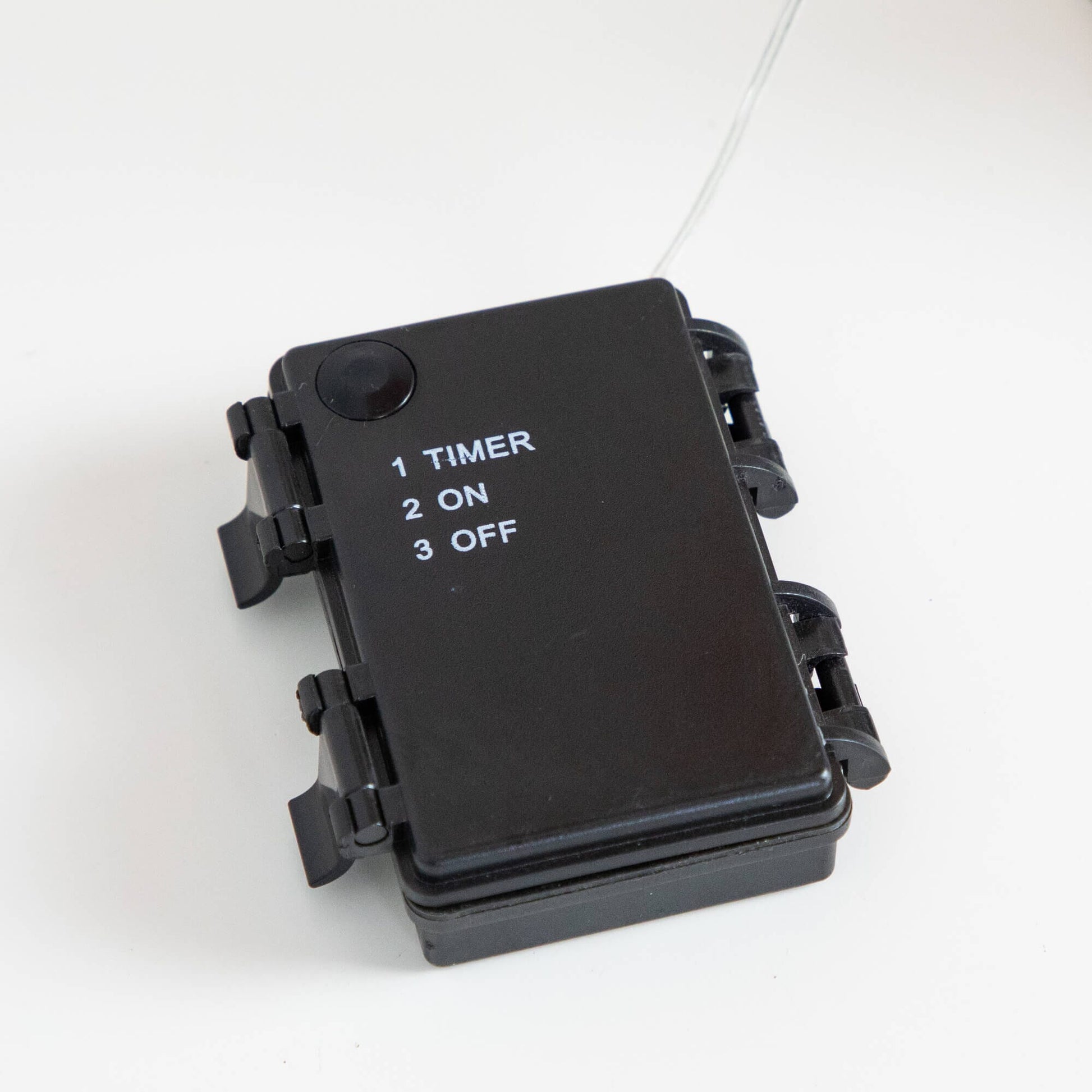 Black plastic timer switch for string lights with 1 TIMER 2 ON 3 OFF and white cord on Tampa Home & Garden Store