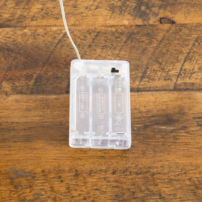 Clear plastic power box with white cord on a rustic wooden table on Tampa Home & Garden Store