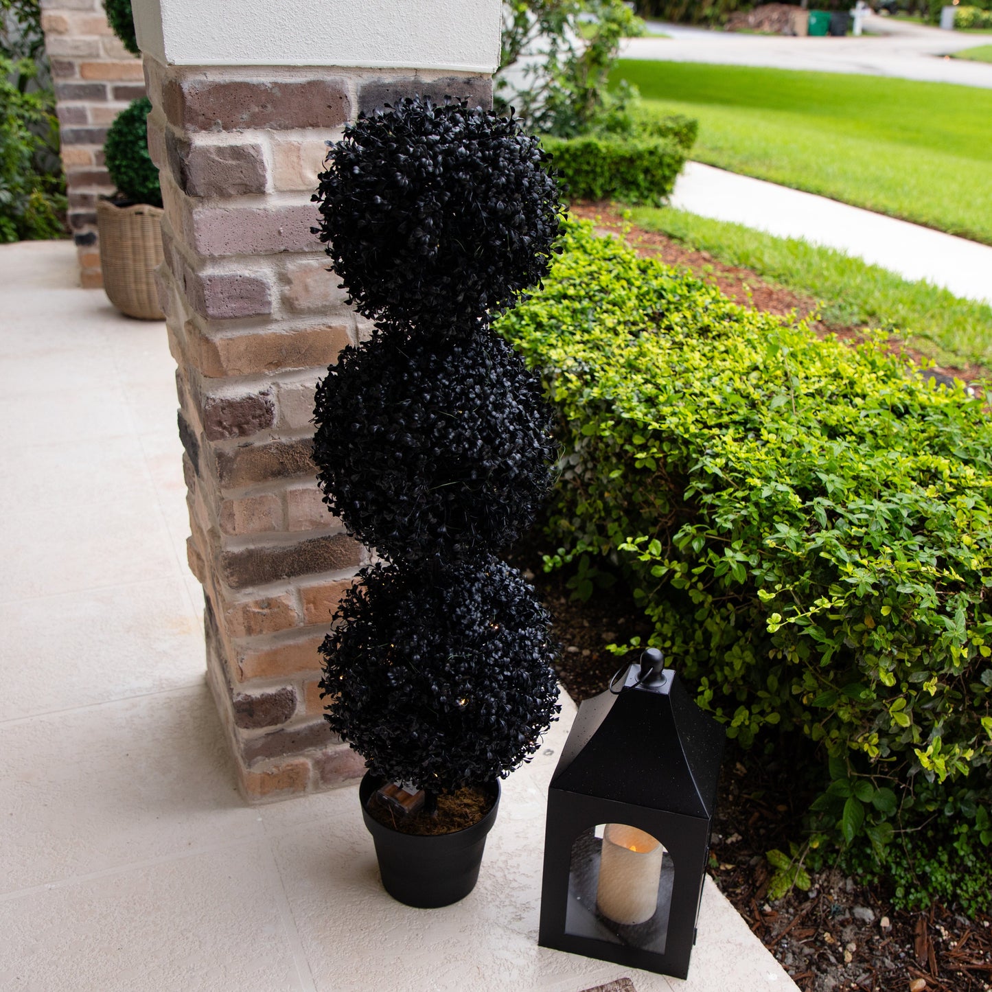 3 ft UV resistant Halloween black artificial triple ball boxwood topiary in black pot beside porch on Tampa Home & Garden Store