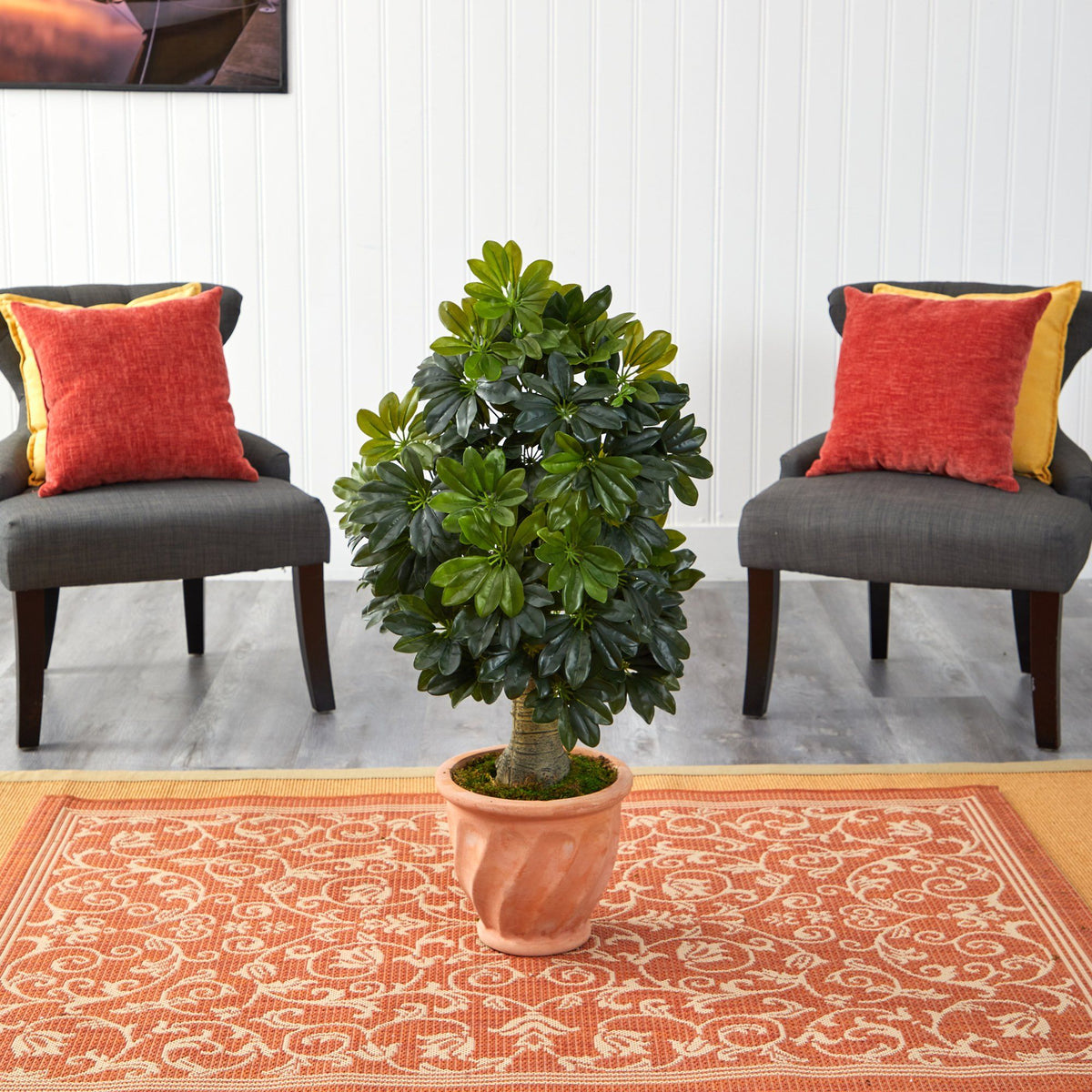 39” Schefflera artificial tree in terra-cotta planter with green leaves between two chairs on Tampa Home & Garden Store
