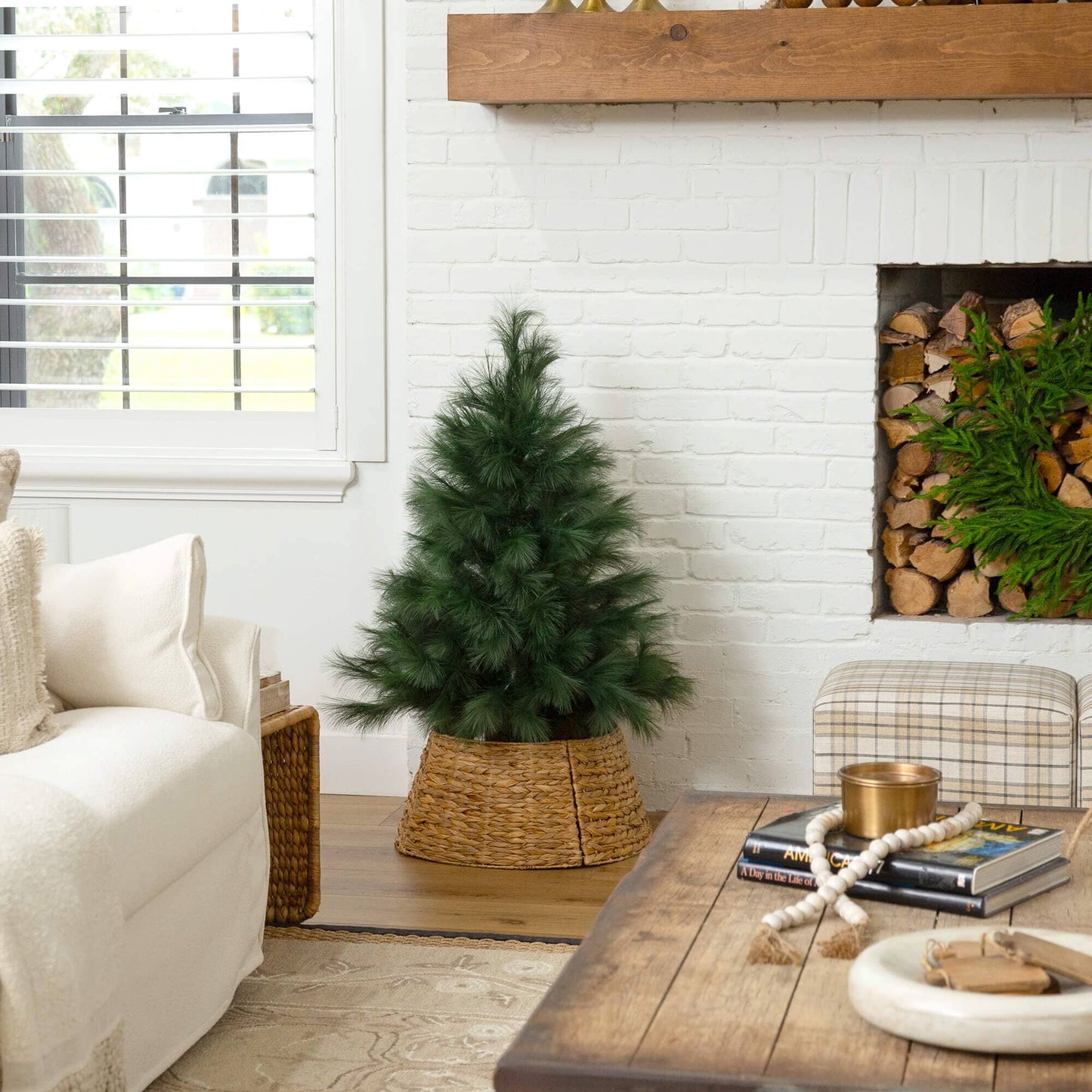 4' artificial green pampas grass Christmas tree in woven basket beside brick fireplace on Tampa Home & Garden Store