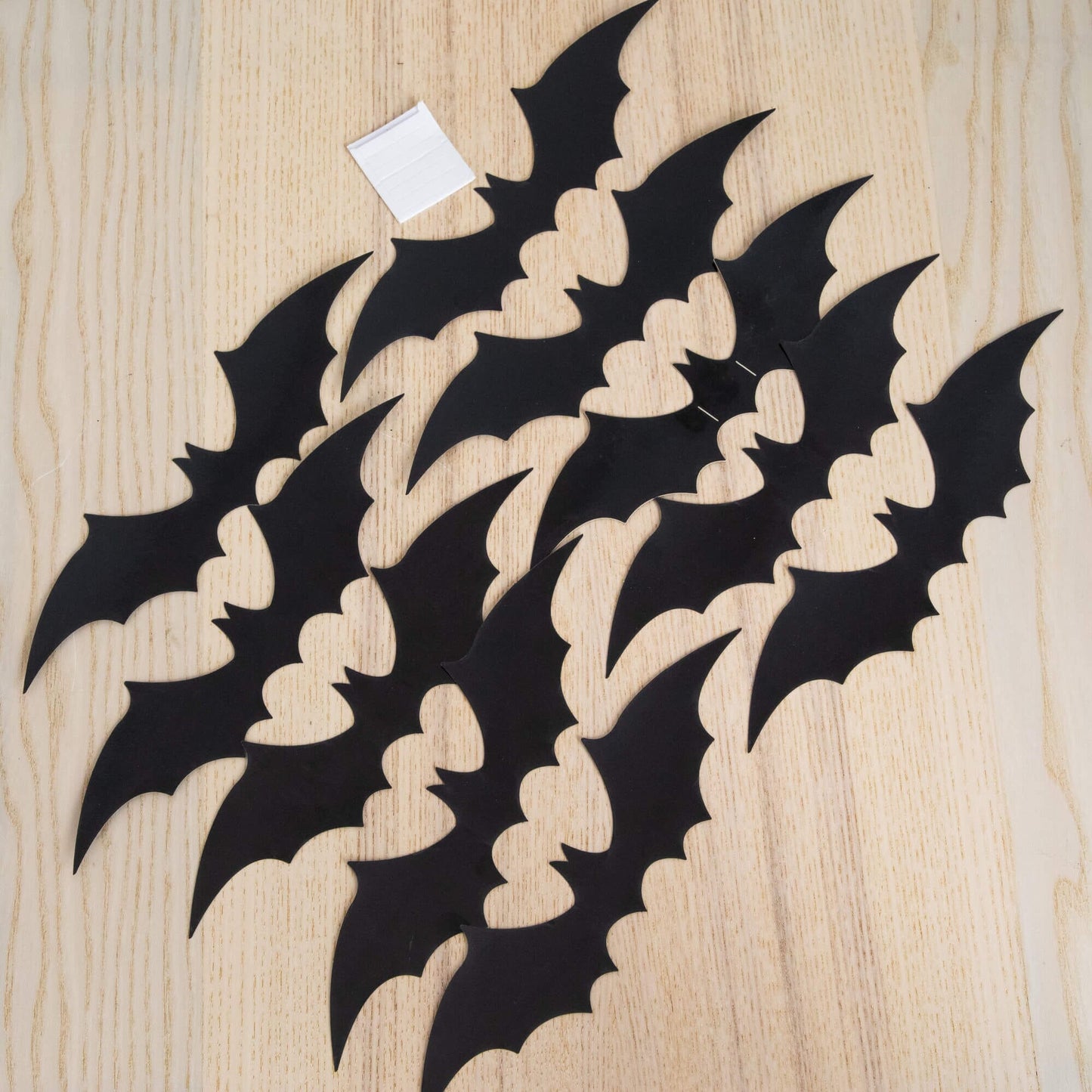 Bat silhouette decorations, multiple black bat shapes on a light wood background on Tampa Home & Garden Store