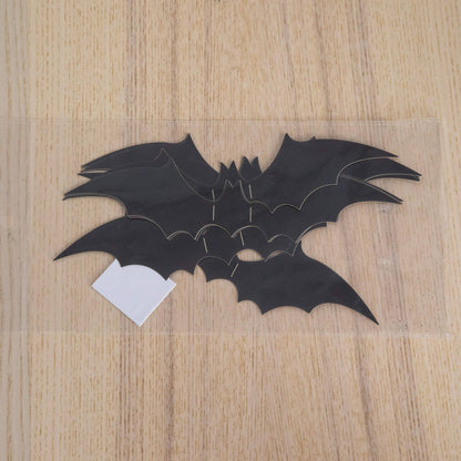 Black Halloween bat cutouts on a light wood surface with a white tag on Tampa Home & Garden Store