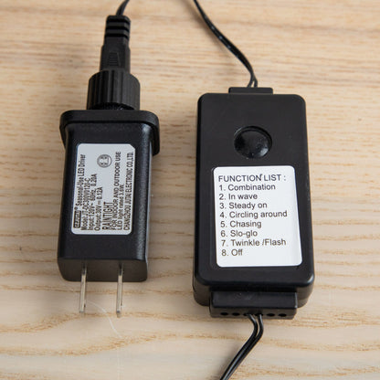 Two black power adapters with white labels and cords on a wooden surface on Tampa Home & Garden Store
