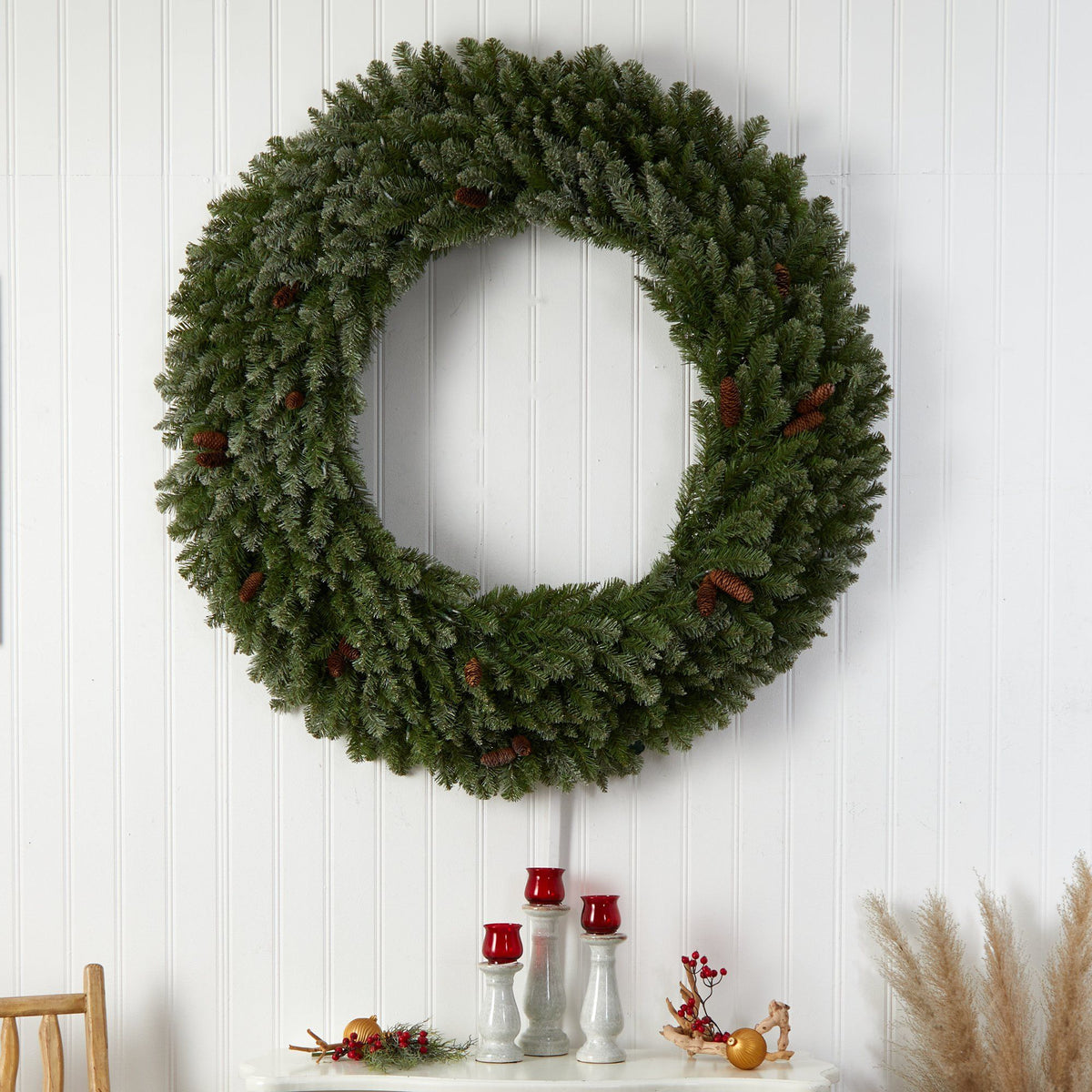 Wreath Nearly Natural 5 ft green flocked Christmas wreath with pinecones on white wall on Tampa Home & Garden Store