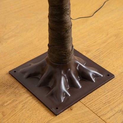 Artificial tree trunk wrapped in brown material with black base on wood floor on Tampa Home & Garden Store